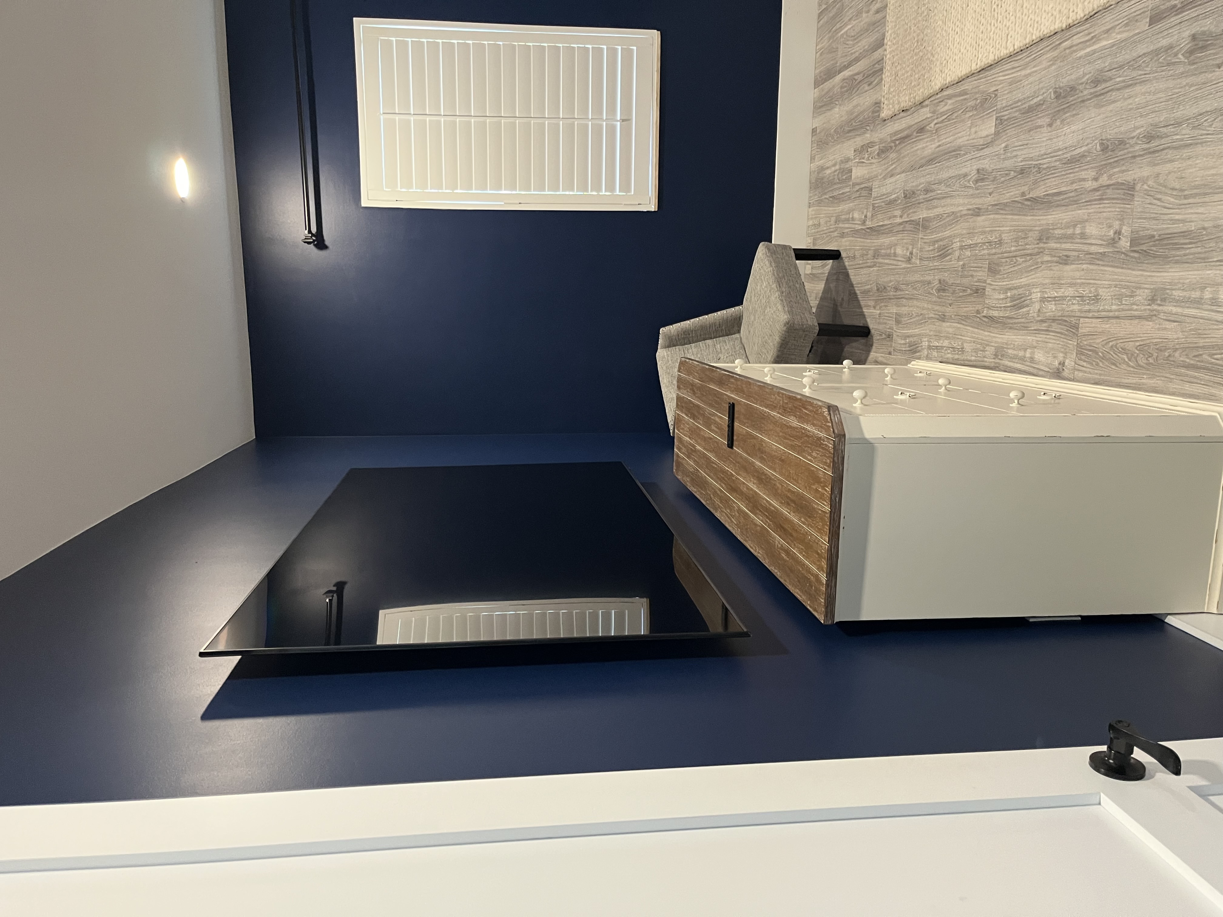 Finished bedroom painting job with deep blue walls, white trim, and a built-in fireplace feature