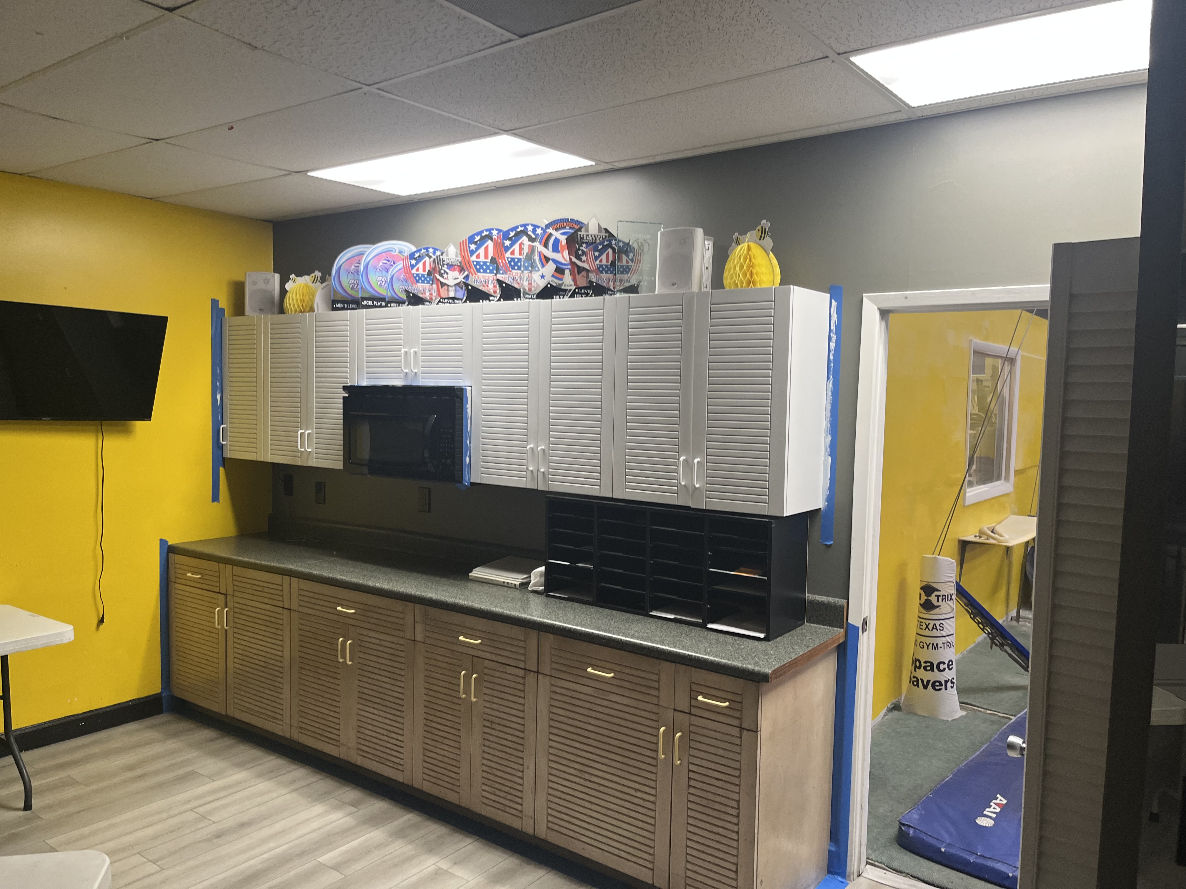 Gymnastics gym cabinets before repainting with darker cabinet fronts