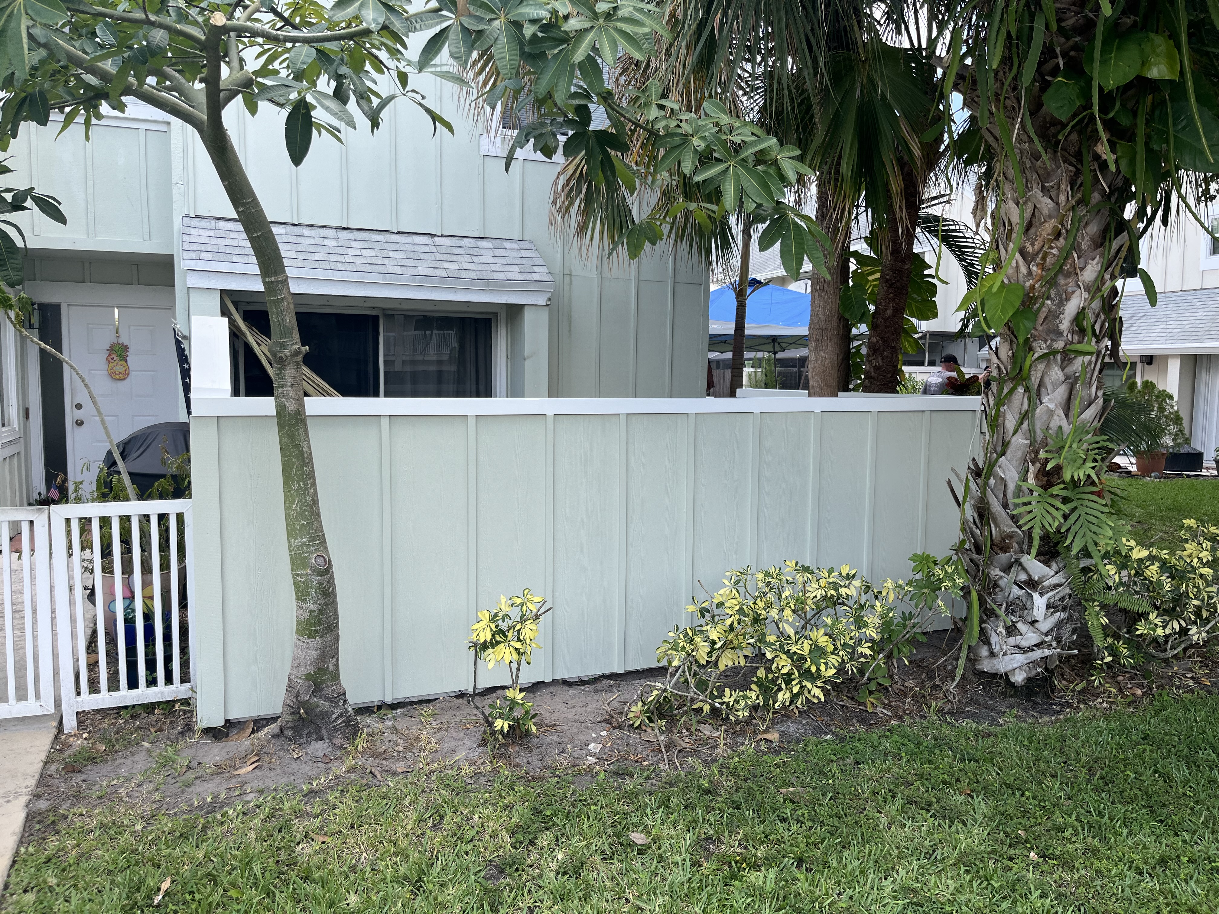 Finished outside view of the newly built fence surrounding the backyard turf project