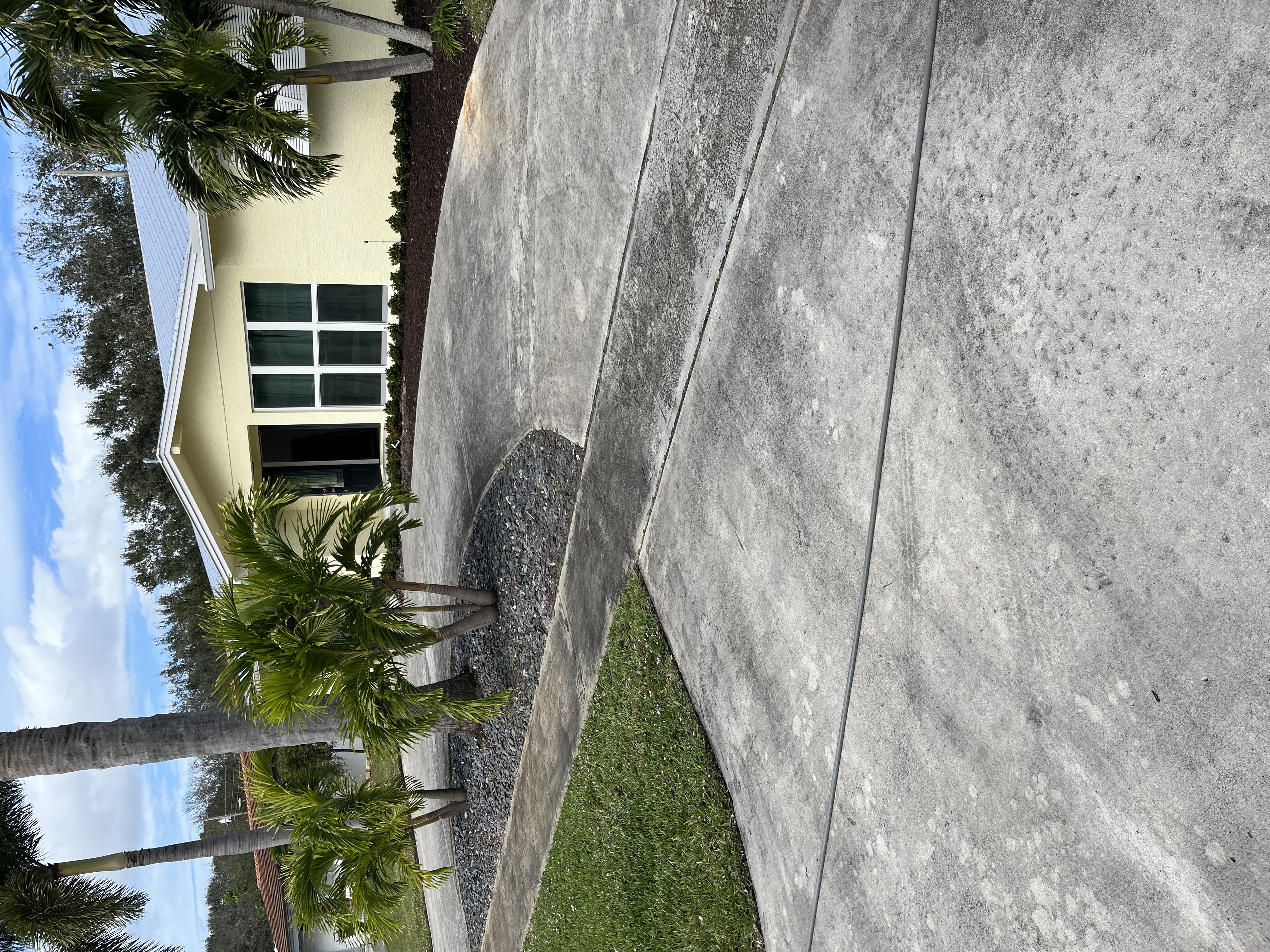 Finished exterior view showing the updated driveway and landscape bed from the side angle
