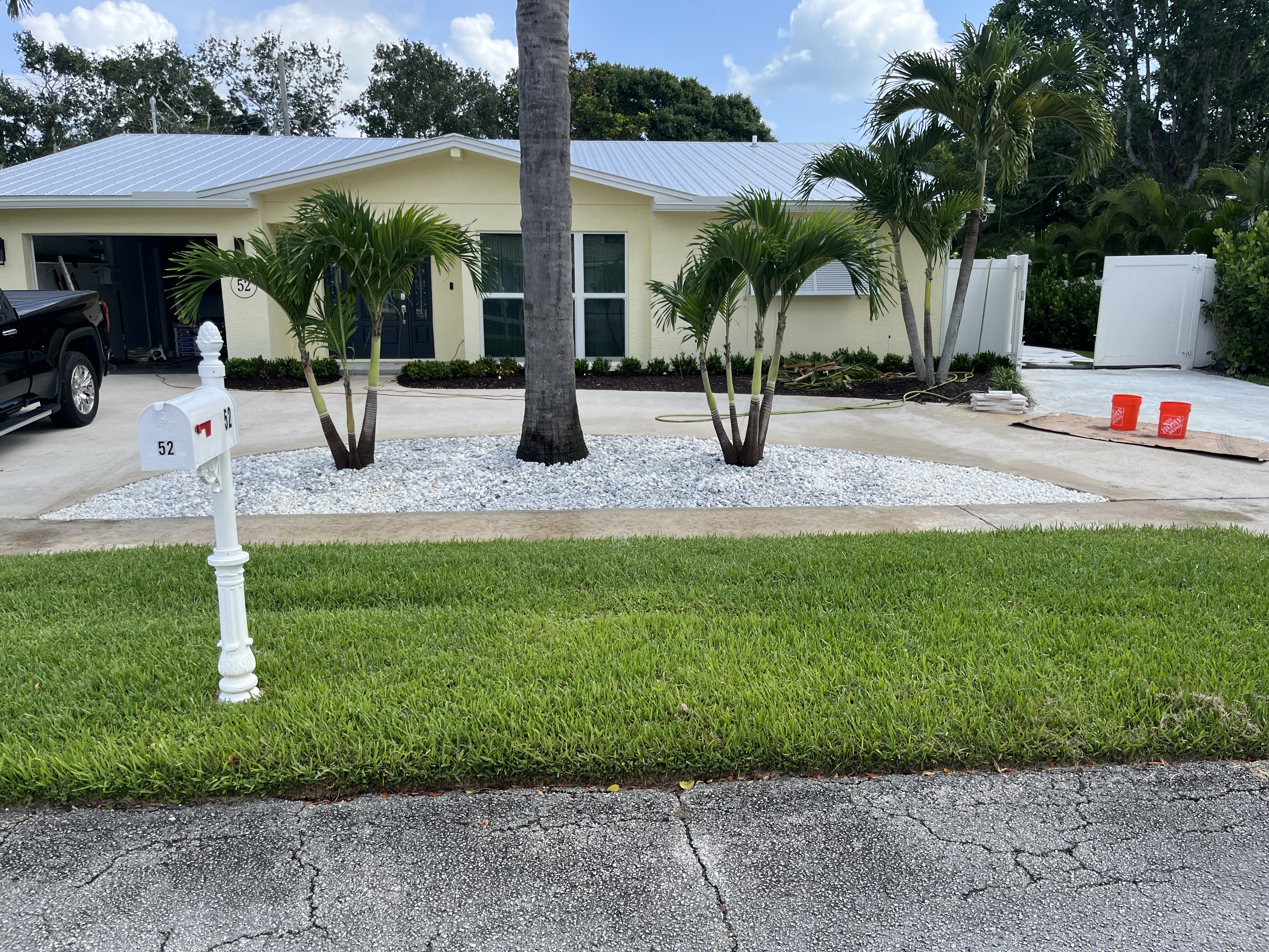 Finished front yard landscape with white stone and refreshed planting beds across the property frontage