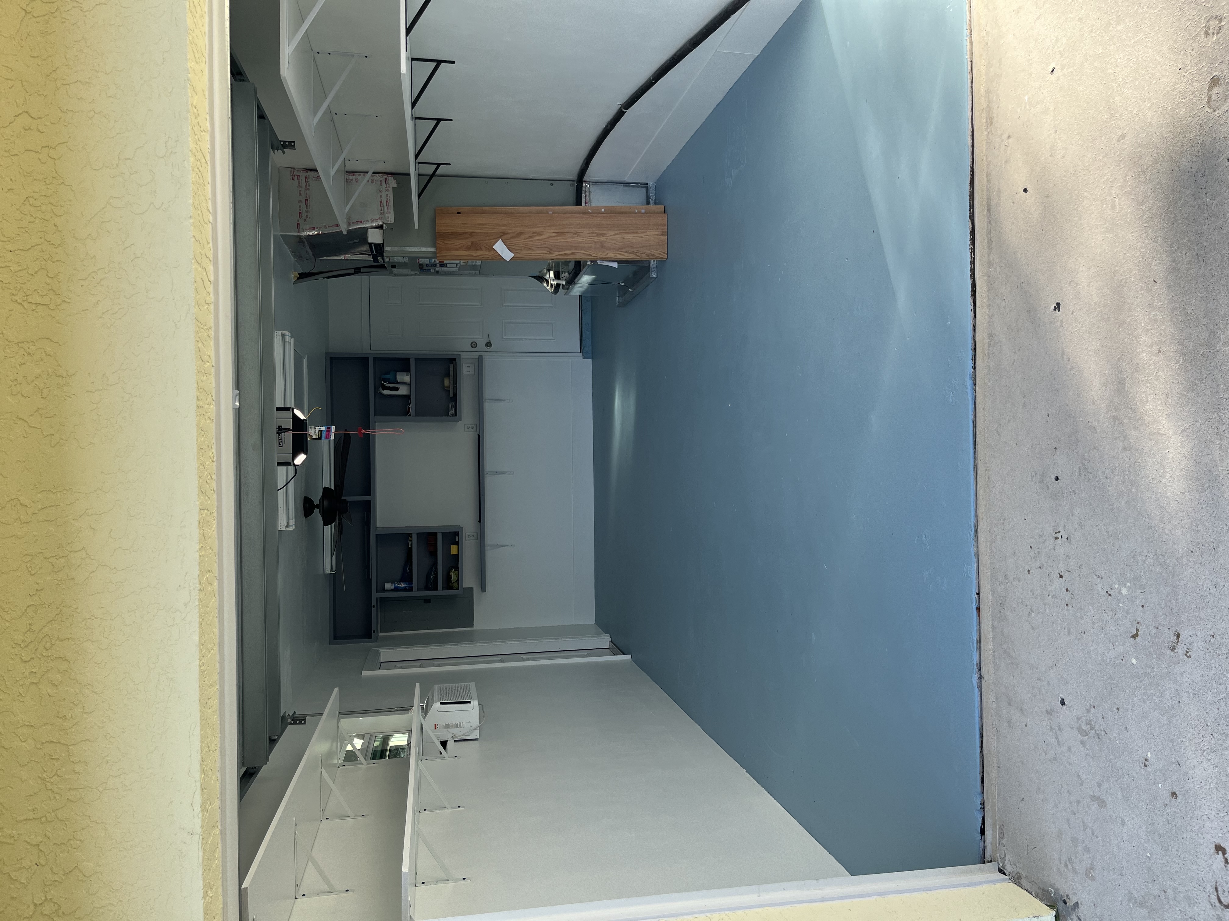 Finished garage floor coating viewed from the garage entrance with the full blue surface visible