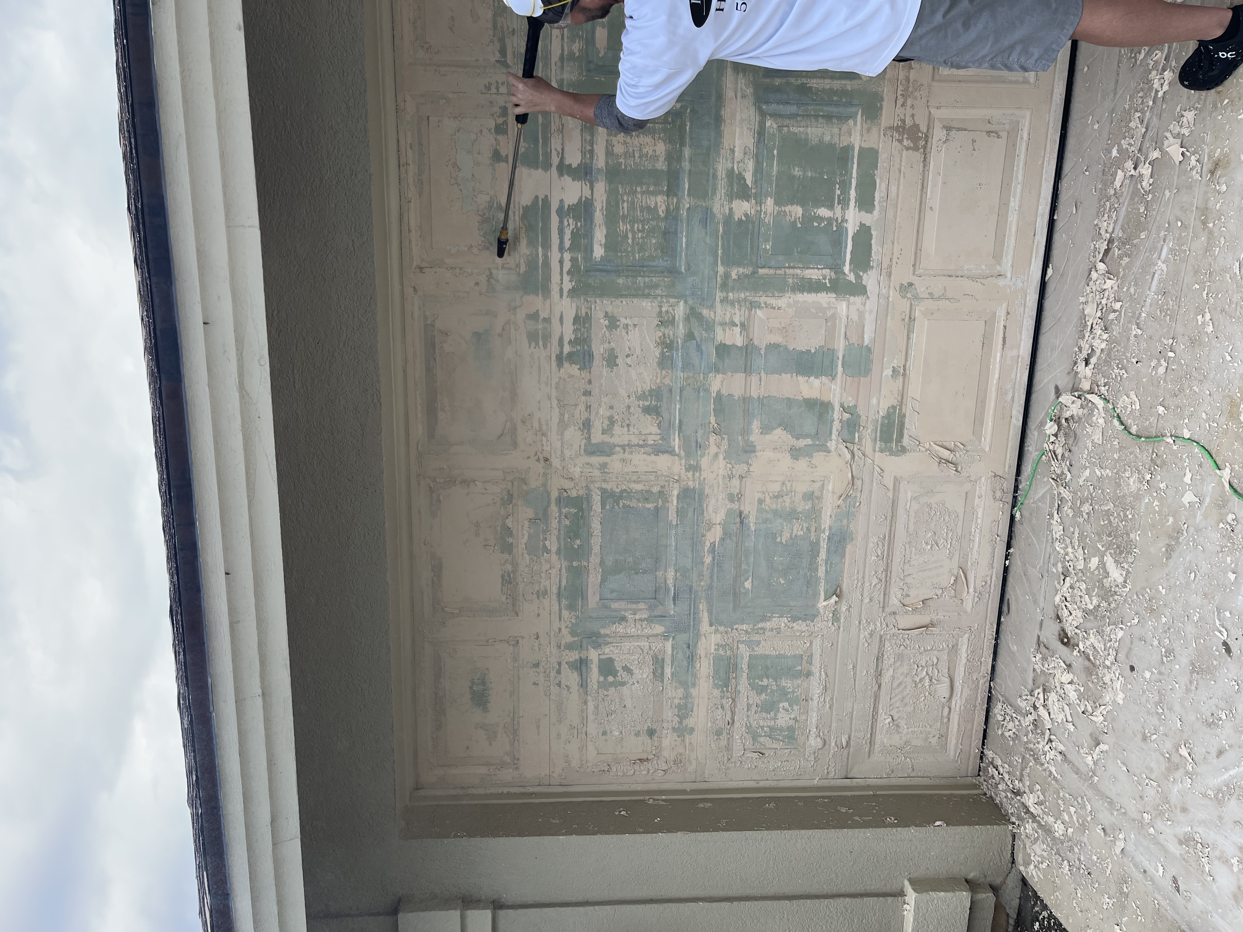 Close-up of the garage door while sanding and surface prep are underway