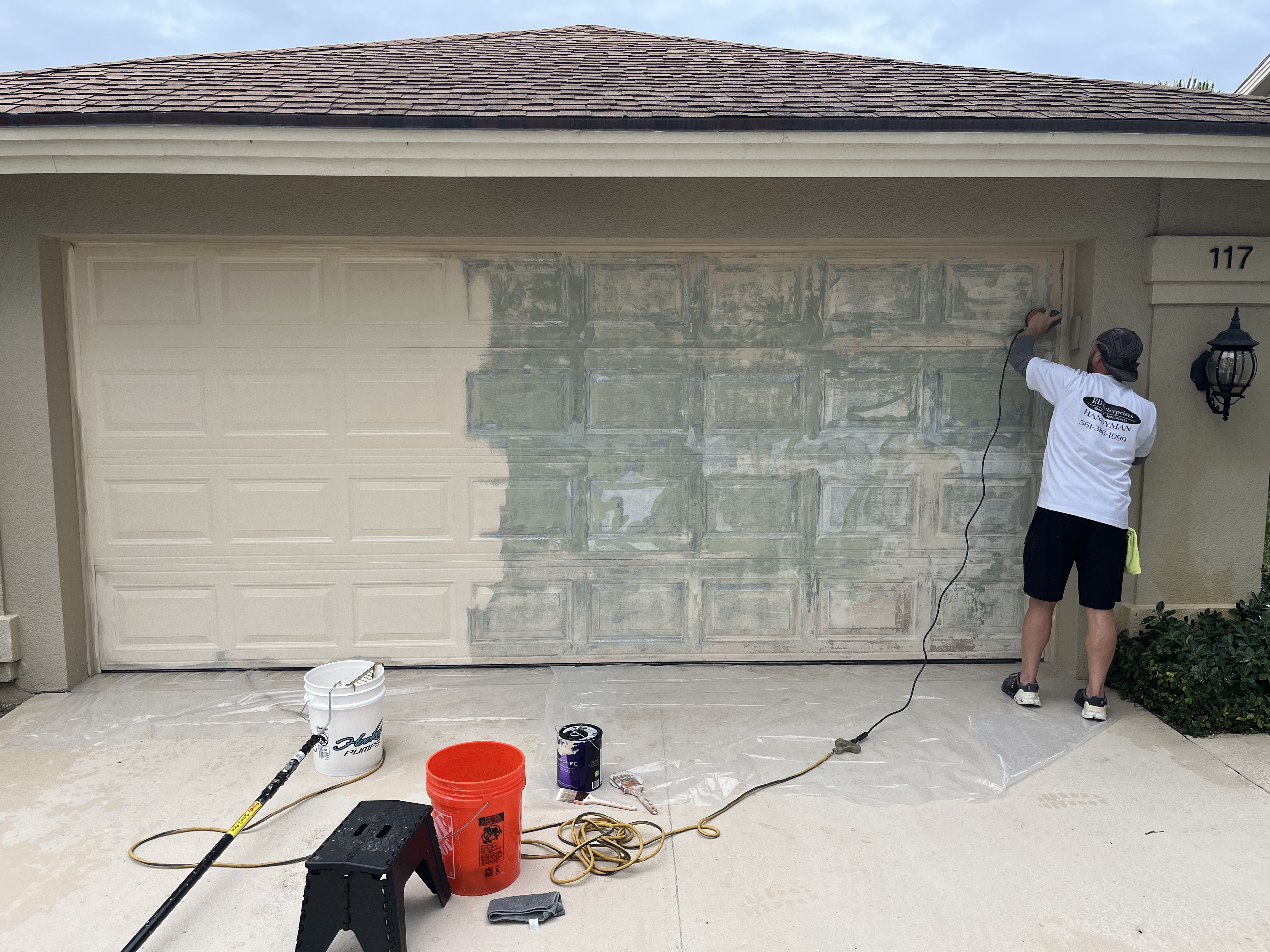 Garage door being repainted with part of the new finish already applied