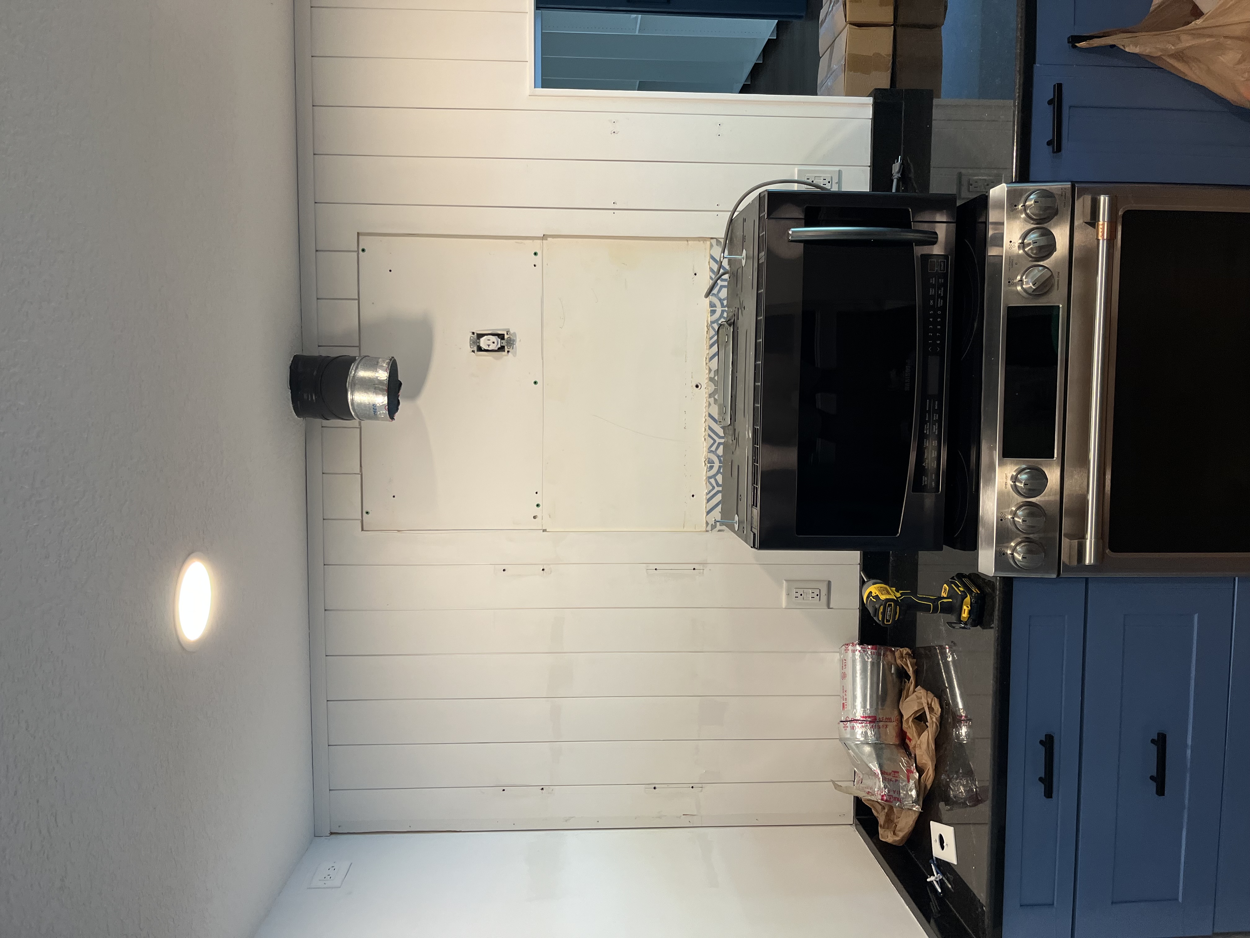 Kitchen wall paneling in progress behind the range area before the final trim and cabinet work were completed
