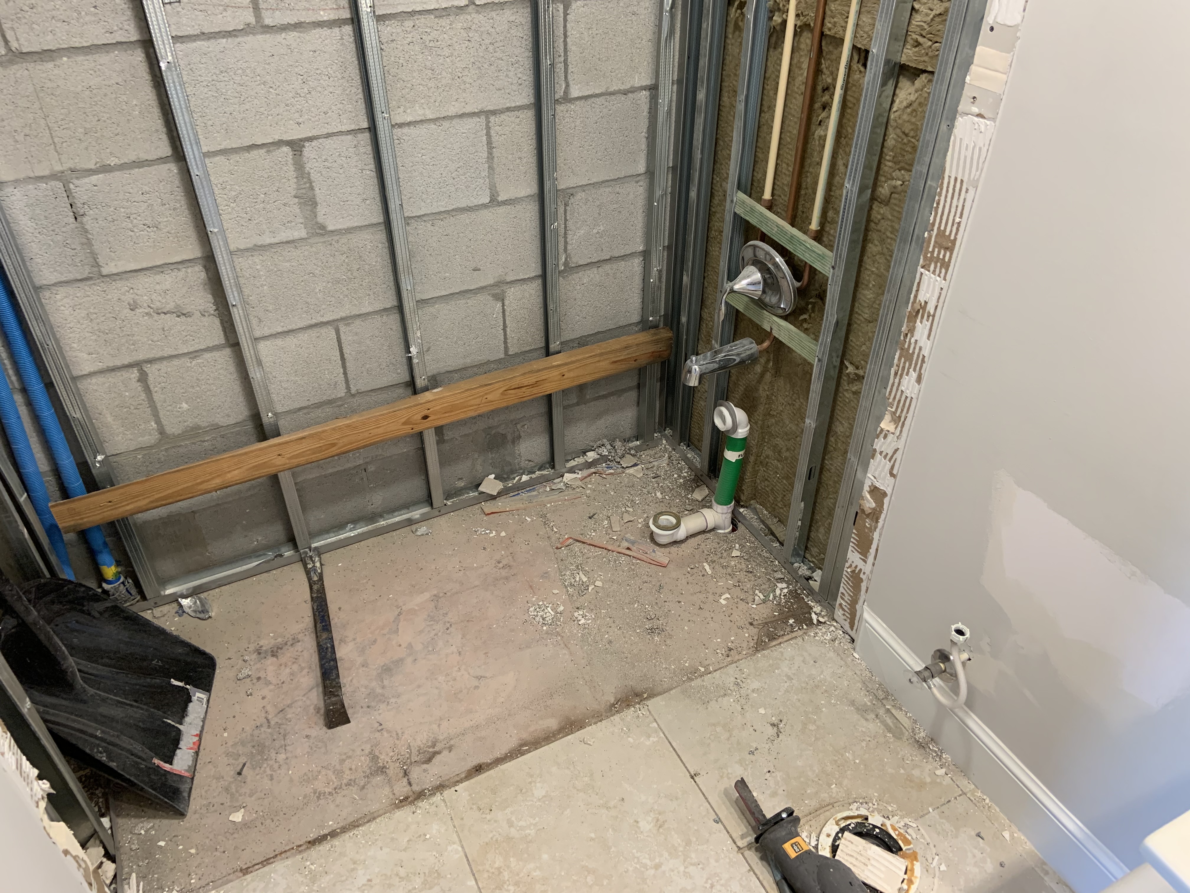Bathroom shower framing and plumbing visible during the remodel preparation phase