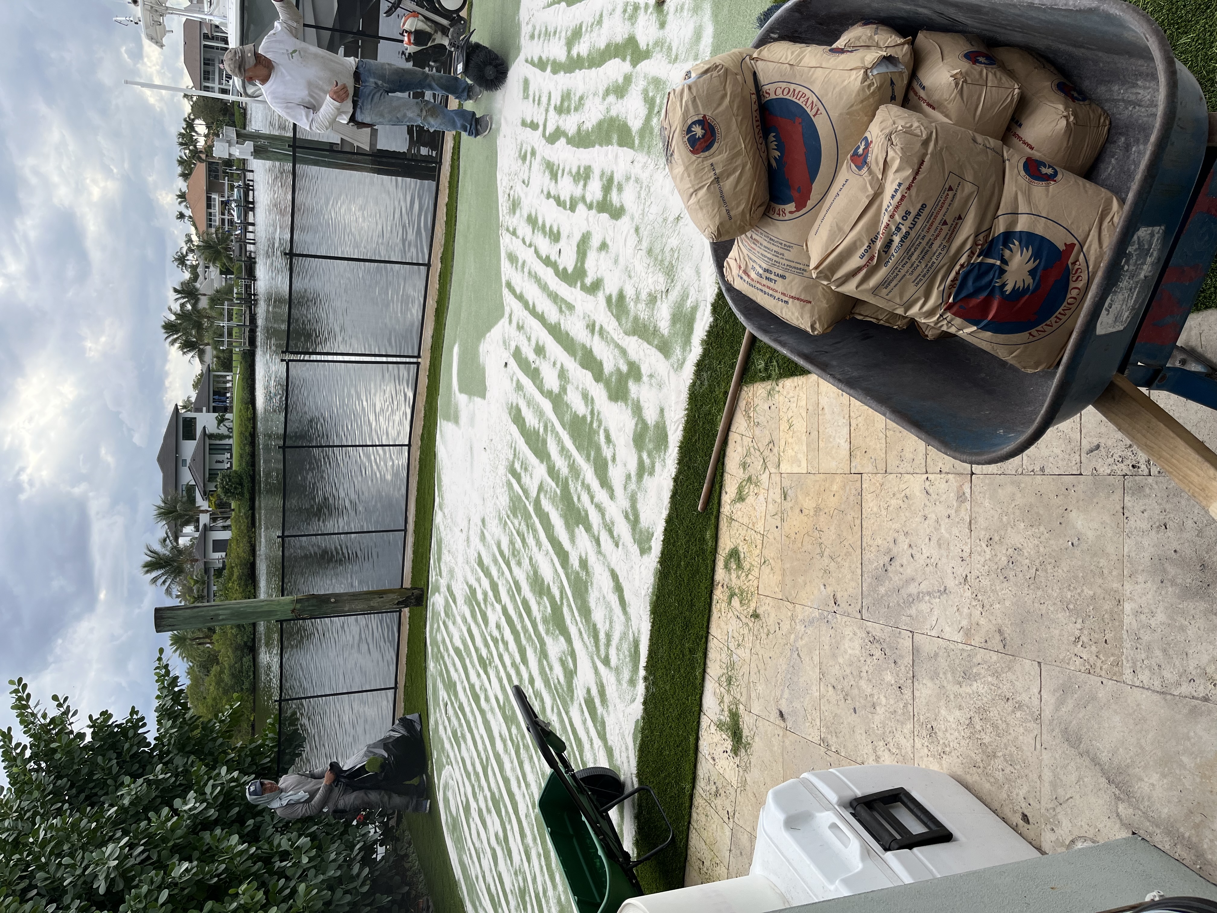 Artificial turf installation in progress with base material spread across the yard